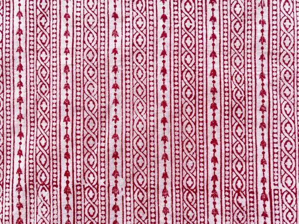 Karmaşık bir kırmızı blok baskılı doğrusal tasarım krem pamuk kumaş boyunca akar, ince işçilik ve gelenek sergiler. 