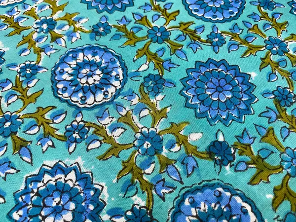 Koyu mavi çiçek desenini yakından görmek için gür yeşil yapraklar, zengin mavi pamuğa basılmış, derinlik ve doğal zarafetin bir karışımını sunar.. 