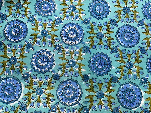 Koyu mavi, gür yeşil yapraklı bir çiçek deseni zengin mavi pamuğa basılmış, derinlik ve doğal zarafetin bir karışımı.. 