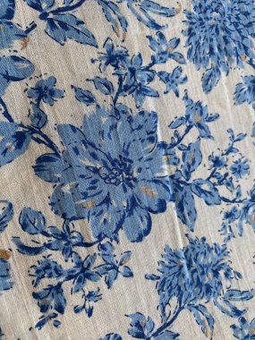 Krem rengi pamuk kumaşları kapatın. Gökyüzü mavisi renginde her yerde bulunan bir çiçek motifi. Yumuşak, rahatlatıcı renk paletiyle incelikli bir zarafet sunuyor..