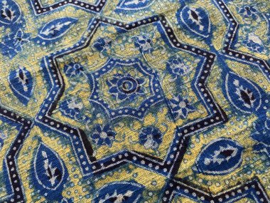 Pamuğa basılmış bloğun yakın görüntüsü çivit, beyaz ve sarı renkli geleneksel Babür geometrik tasarımı ile. 