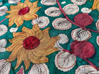 Bu pamuk kumaş geleneksel Kalamkari sanatını doğal ve dünyevi renklerde narin çiçek motifleriyle sergiliyor..