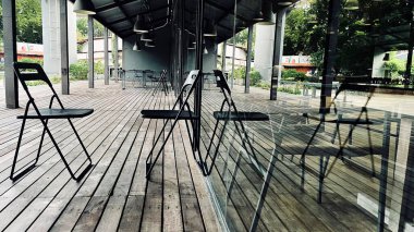 Dışarıdaki restoranda boş tahta sandalyeli güneş ışığı. 