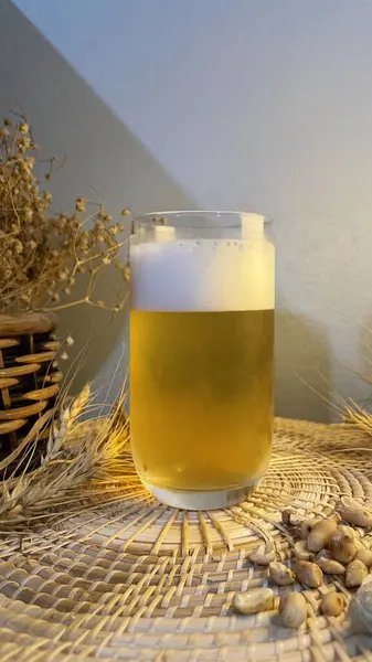 Masada bir bardak bira ve bir kupa bira var.