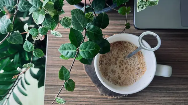 Kahve fincanı, bilgisayar klavyesi, defter, kalem.