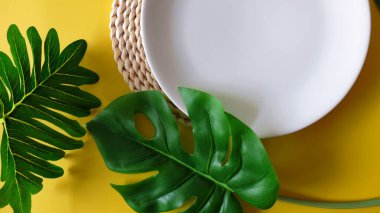 Beyaz tabakta tropikal yapraklar ve canavarlar