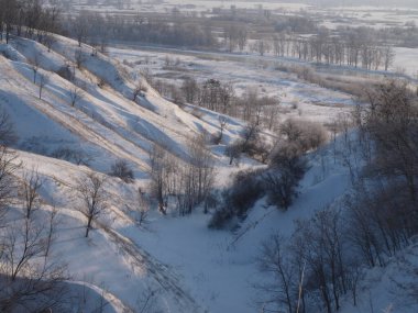 Fotoğrafta bir kış manzarası gösteriyor. Dağlar, çayırlar..