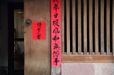 Eski bir sokak arasında, bir evin kırmızı bahar çifti göze çarpıyor, bayram rengi ekliyor ve Çin geleneğinde daha iyi bir yaşam umudunu simgeliyor..