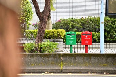 Taiwan - Jan 29, 2024: Close-up of a Chunghwa Post Mailbox on a Taipei City sidewalk. Chunghwa Post (1896): Taiwan's mail service (letters, parcels). Key state business driving economic growth. clipart