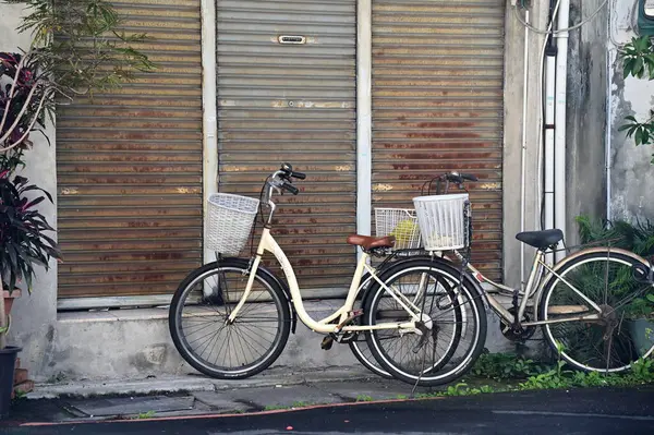 stock image Taiwan - Jan 29, 2024: This photo depicts a daytime scene in an alley with two parked bicycles. The house behind them is closed, creating a tranquil atmosphere and highlighting the charm of traditional Taiwanese alleys.