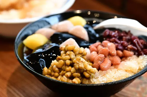 Yaz Serinlemesi: Taze Taro Ball Tıraşlı Buz. Tıraş edilmiş buz, taro topları, tatlı patates topları, şekerli su ve kırmızı fasulye, yeşil fasulye ve mung fasulyesi gibi çeşitli malzemelerle çok sevilen bir yaz ziyafeti.