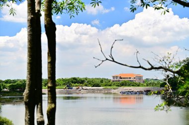 On a summer day under a blue sky and white clouds, the lake and mountain scenery of Hutoupi Scenic Area in Tainan showcases Taiwan's natural beauty. clipart