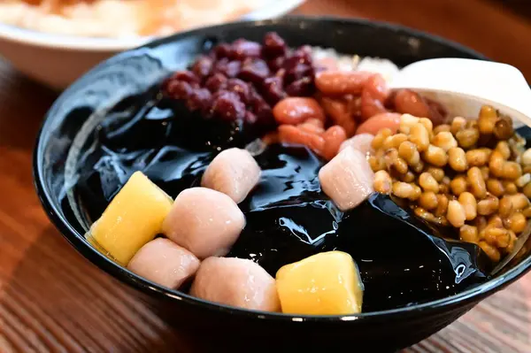 Yaz Serinlemesi: Taze Taro Ball Tıraşlı Buz. Tıraş edilmiş buz, taro topları, tatlı patates topları, şekerli su ve kırmızı fasulye, yeşil fasulye ve mung fasulyesi gibi çeşitli malzemelerle çok sevilen bir yaz ziyafeti.