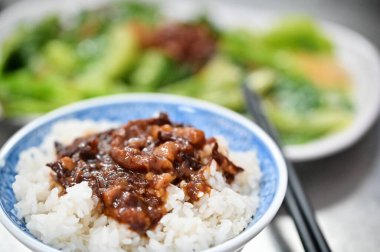 Lezzetli haşlanmış domuz pirinci, taze domuz eti ve soya sosunu birleştirir. Bu yemek, beyazlatılmış sebzelerin ferahlatıcı tadı, zenginlik ve tazeliği dengeleyen ışıkla tamamlanır..