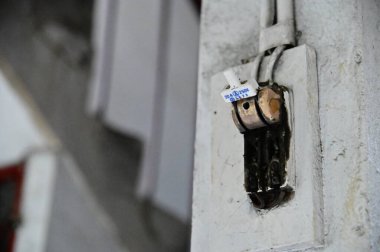 A ceramic knife switch on the wall of a residential building, soon to undergo redevelopment, highlights its significance in Taiwan's electrical appliance history. clipart