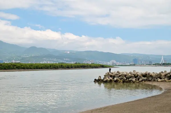Taipei 'deki Shezidao Riverside Parkı, balıkçıların dalga kırıcılarla avlandığı, Keelung ve Tamsui nehirlerinin birleştiği yer. Guanyinshan ve Datun volkanik aralığının panoramik görüntülerini sunar..