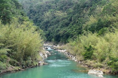 Three Diao Ling 'de, Keelung Nehri el değmemiş bir dağ manzarasının içinden akar, nehir yatağı boyunca aşınmış kayalar doğanın gücünü ve güzelliğini gösterir..