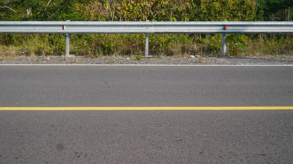 stock image photo of the highway with yellow markings and iron barriers