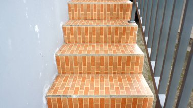 Kırmızı tuğla motifli seramik ve gri demir tırabzanlarla kalıcı ev merdivenleri.