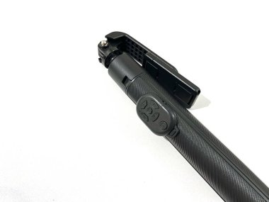 Beyaz arkaplanda kablosuz uzaktan izole edilmiş katlanmış akıllı telefon tripodu