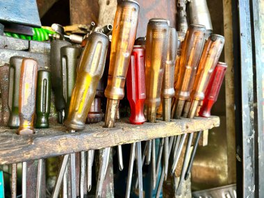 Tamirhanedeki ahşap askıda şeffaf saplı tornavidalar.