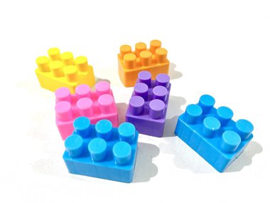 Beyaz arka planda plastikten yapılmış renkli yapı taşı oyuncakları grubu