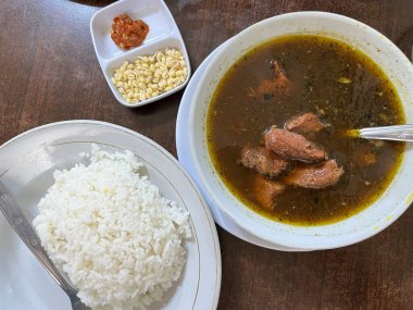 Rawon adındaki geleneksel Endonezya yemeği beyaz bir kasede siyah sığır eti çorbasından oluşur. Fasulye filizi, acılı sambal ve pilav ile servis edilir.