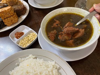 Rawon adındaki geleneksel Endonezya yemeği beyaz bir kasede siyah sığır eti çorbasından oluşur. Fasulye filizi, acılı sambal ve pilav ile servis edilir.