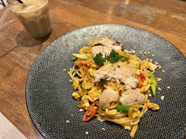 Baharatlı spagetti, tavuk eti, kırmızı biber, omlet ve taze soğan. Lüks bir tabakta servis ediliyor.