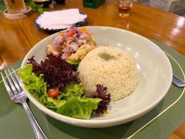 Bir tabak tereyağlı pilav, kızarmış balık, marul salatası ve Balili Sambal Matah.