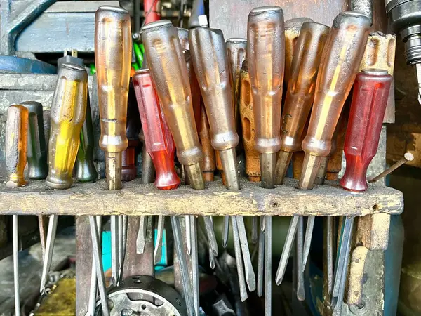 stock image Set of screwdrivers with transparent handle on a wooden rack inside a repair shop garage