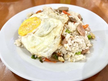 Endonezya usulü ev yapımı kızarmış pilav ya da Nasi Goreng 'in köfteli, sosisli ve tepside güneşli yumurta görüntüsü.