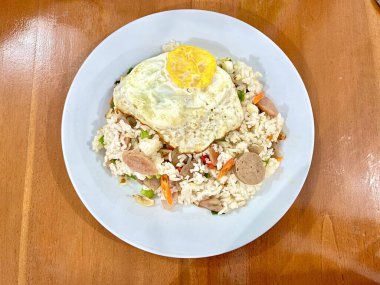 Endonezya usulü ev yapımı kızarmış pilav ya da Nasi Goreng 'in köfteli, sosisli ve tepside güneşli yumurta görüntüsü.