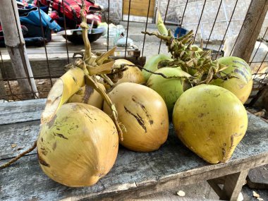 Tropikal bir plajın etrafındaki yiyecek tezgahında satılık taze hindistan cevizi var.