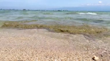 Köpüklü deniz dalgaları kumsala vuruyor güneşli yaz güneşinde Endonezya 'nın Gili Ketapang kentindeki turistleri silip süpürüyor.