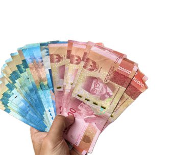 Asyalı bir adamın eli kahverengi tenli bir avuç Endonezya Rupiası para destesi beyaz arka planda izole edilmiş