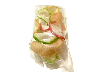 Beyaz arka planda izole edilmiş plastik bir ambalajda çok renkli çıtır karides kraker paketi.