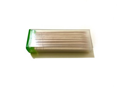 Beyaz arka planda izole edilmiş plastik bir kapta bir paket bambu kürdan.