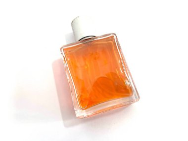 Beyaz arka planda izole edilmiş turuncu sıvı ve gümüş kapaklı cam parfüm şişesi. Kozmetik, güzellik veya kokuya bağlı tasarım ve reklam kullanımı için zarif bir koku kapsülü.