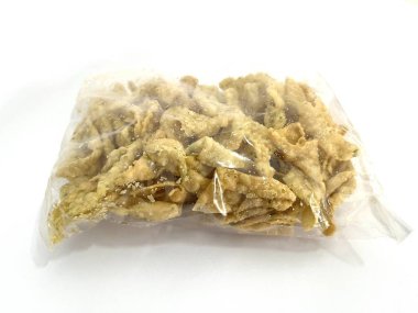 Beyaz arka planda izole edilmiş plastik bir torbada kızarmış wonton cipsi ya da Pangsit Goreng. Çıtır çıtır ve baharatlı Asya atıştırmalıkları çorba, erişte ve salata için mükemmel..