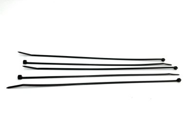 Beyaz arka planda izole edilmiş siyah kablo. Kablo, elektronik ve aletleri düzenlemek için dayanıklı ve esnek kablo bağları. Ev, ofis veya endüstriyel kullanım için gerekli.