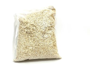 Plastik rulo yulaf paketi. Satılık ya da depolanmaya hazır. Kahvaltı ya da pişirme için doğal sağlıklı gıda ürünü. Beyaz arkaplanda izole.