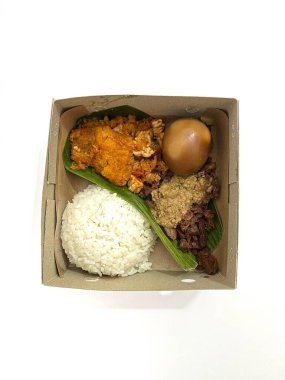 Endonezya 'nın geleneksel pirinç kutusu yemeği Nasi Gudeg, yumurta, karabuğday güveci, Krecek ve pilav. Otantik Cava yemekleri. Beyaz arkaplanda izole.