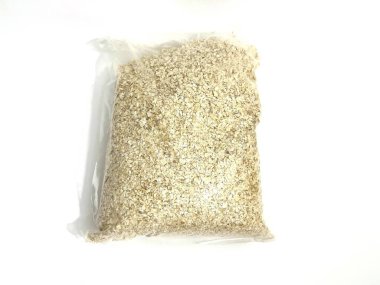 Plastik rulo yulaf paketi. Satılık ya da depolanmaya hazır. Kahvaltı ya da pişirme için doğal sağlıklı gıda ürünü. Beyaz arkaplanda izole.