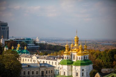 Ortodoks Kilisesi 'nin güzel sarı ve altın kubbeleri mavi gökyüzünün ve şehrin arka planına karşı. Kiev-Pechersk Lavra Katedrali 'nin Kubbeleri.