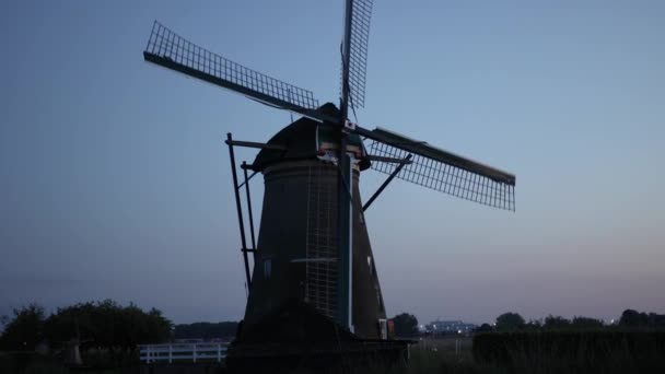 キンダーダイクのオランダ村の日没時に美しい木製の風車 風車は風に乗って走る 美しいオランダの運河には水が満ちています 美しい夕日 — ストック動画