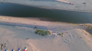 Yazın Katwijk aan Zee sahilinde güzel bir uçuş. İnsanlar deniz kenarında dinleniyor. Turistler için evler. Plaj şemsiyeleri, gezintiler, denizde yüzen insanlar. Hollanda 'da bir plaj. Kuzey Denizi.