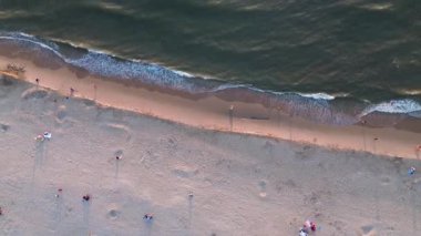 Yazın Katwijk aan Zee sahilinde güzel bir uçuş. İnsanlar deniz kenarında dinleniyor. Turistler için evler. Plaj şemsiyeleri, gezintiler, denizde yüzen insanlar. Hollanda 'da bir plaj. Kuzey Denizi.