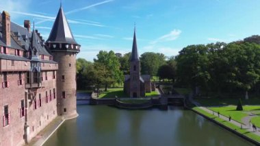 Hollanda 'nın en büyük şatosunun manzarası, De Haar. Şatonun, parkın ve kalenin etrafındaki su hendeğinin üzerinde güzel bir kuadkopter uçuşu. İngiliz tarzında güzel bir park..