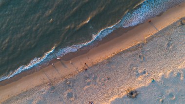 Yazın Katwijk aan Zee sahilinde güzel bir uçuş. İnsanlar deniz kenarında dinleniyor. Turistler için evler. Plaj şemsiyeleri, gezintiler, denizde yüzen insanlar. Hollanda 'da bir plaj. Kuzey Denizi.